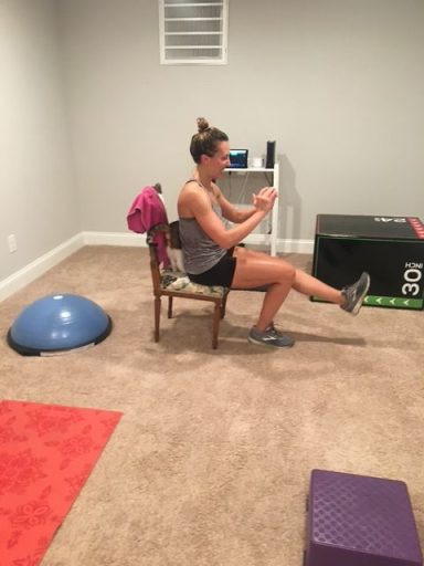 Master Balance A person performs an exercise while sitting on a chair, with fitness equipment nearby.
